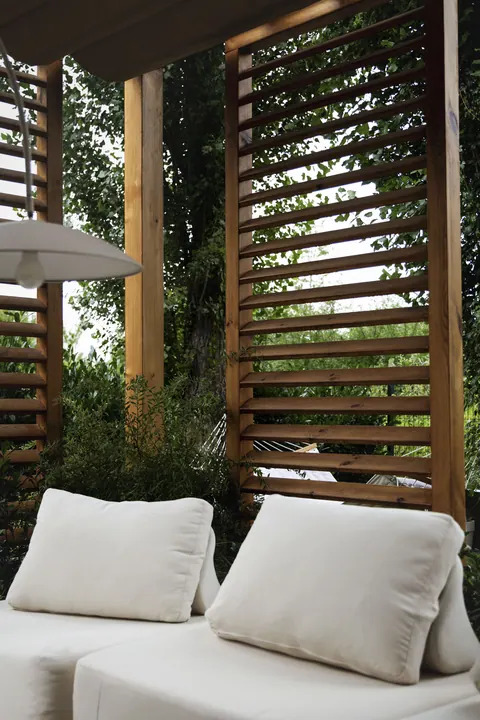 Pergola z lamelami i strefą wypoczynku w ogrodzie