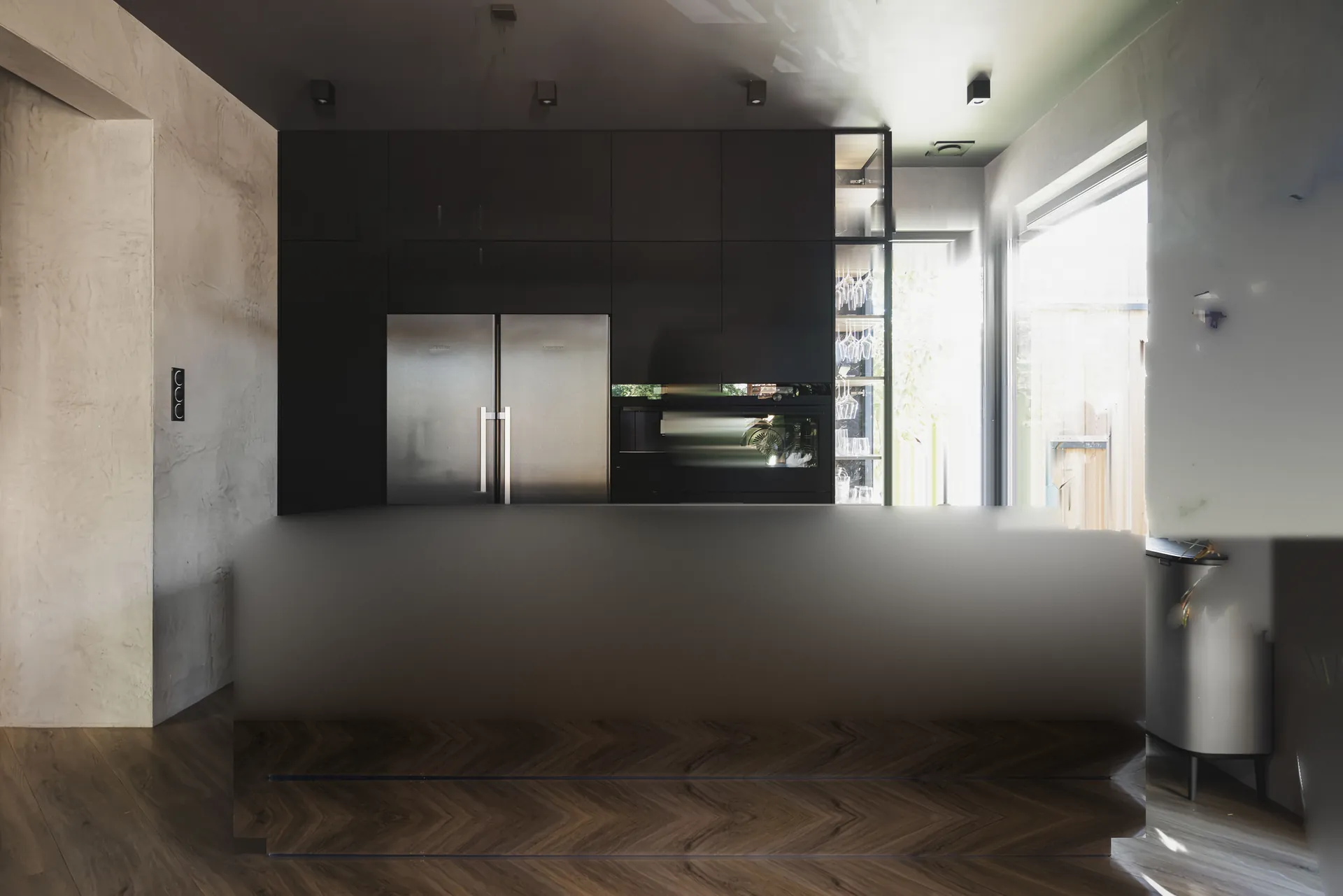 Nowoczesna czarna kuchnia na wymiar z wyspą z kamienia naturalnego i lampą wiszącą – realizacja KUHNE STUDIO we Wrocławiu